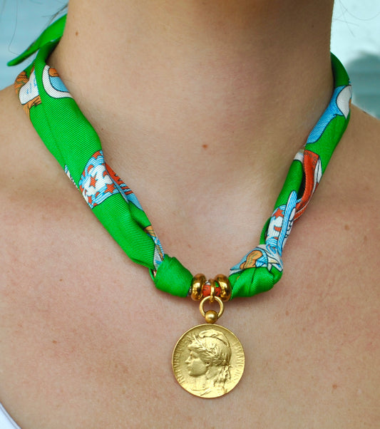 Emerald green printed silk scarf necklace with antique gold medallion portrait pendant worn around neck