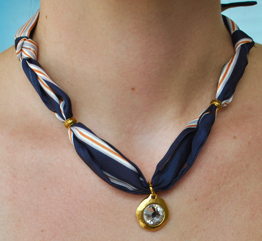 Navy white and orange stripe silk scarf necklace with gold bezel crystal pendant worn around neck