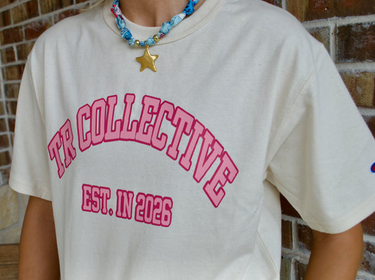 Close-up of pink TR Collective and EST. IN 2025 lettering on a cream tee